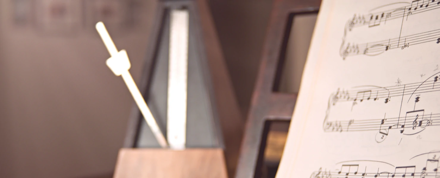 ピアノの上のメトロノームと楽譜のレトロな写真